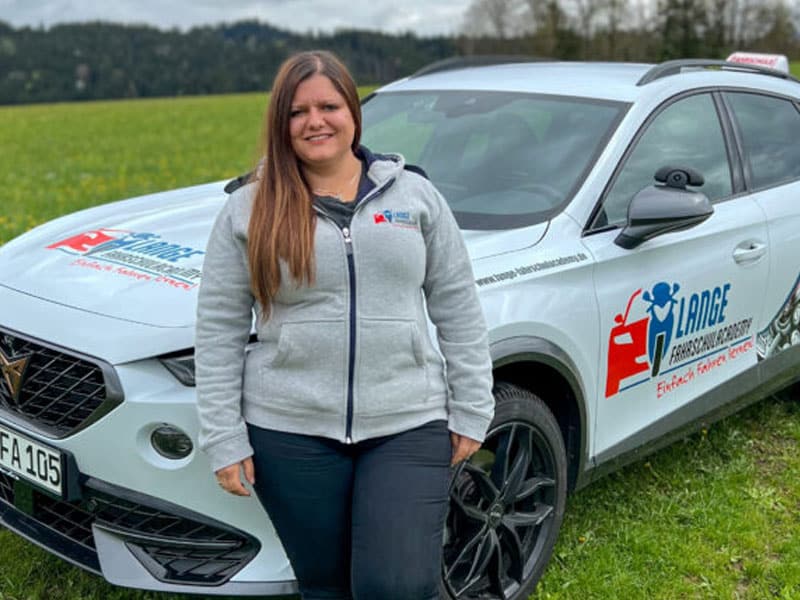 Fahrlehrerin Zita Lange vor dem Fahrschulauto der Lange FahrschulAcademy.
